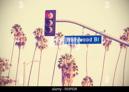 Vintage retro toned Hollywood boulevard sign and traffic lights with palm trees in the background, Los Angeles, USA. Stock Photo