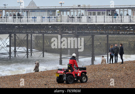 Brighton, UK. 15th Nov, 2015. A member of Brighton Lifeguard beach patrol keeps an eye on members of the public along Brighton seafront as gale force winds and rain batter the south coast. The remnants of Hurricane Kate are forecast to affect areas of Britain throughout the next few days with Storm Barney also approaching Credit:  Simon Dack/Alamy Live News Stock Photo