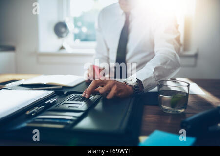 close up, business man or lawyer accountant working on accounts using a calculator and writing on documents Stock Photo