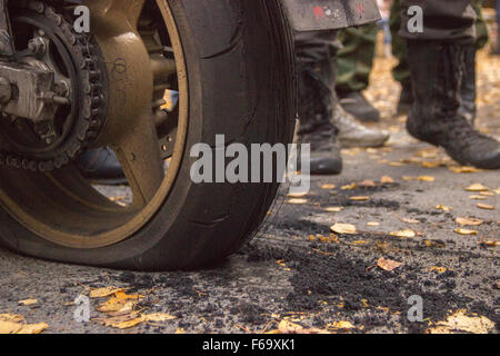 Motorcycle burned tire on the pavement and motorcyclists Stock Photo