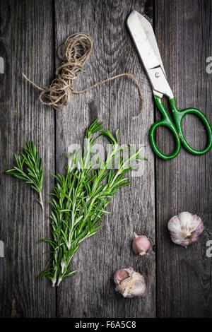 Rosemary, salt and pepper on wooden cutting board, copy space. Cooking food background Stock Photo