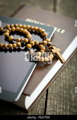 wooden rosary beads with computer tablet on old wooden table Stock Photo