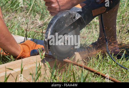 workers cuts rebar circular power saw outdoor closeup Stock Photo