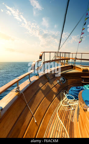 Wooden sailboat in turquoise sea at sunset Stock Photo