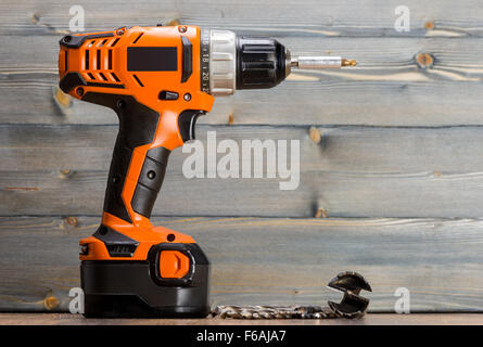 battery powered drill and drill on a wooden surface Stock Photo