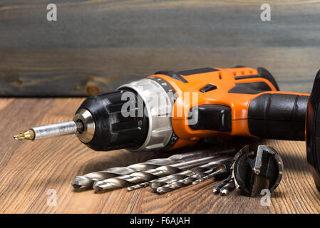 battery powered drill and drill on a wooden surface Stock Photo