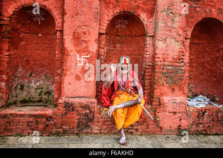 Wandering  Shaiva sadhu (holy man) with traditional face painting in ancient Pashupatinath Temple Stock Photo