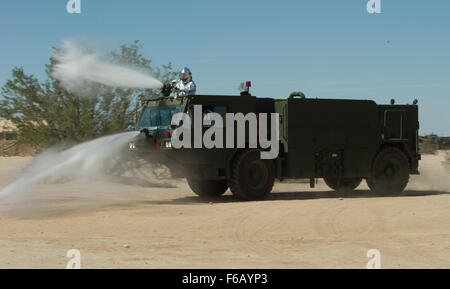 U.S. Marines with Marine Wing Support Squadron 374, Aircraft Rescue and Firefighting, demonstrate a handline drill to the Air Ground Support students at Weapons and Tactics Instructor (WTI) Course 1-16 training area on Sept. 19, 2015, Yuma, Ariz. This familiarization tour is apart of WTI 1-16, a seven week training event, hosted by Marine Aviation Weapons and Tactics Squadron One (MAWTS-1) cadre, which emphasizes operational integration of the six functions of Marine Corps aviation in support of a  Marine Air Ground Task Force. MAWTS-1 provides standardized advanced tactical training and certi Stock Photo