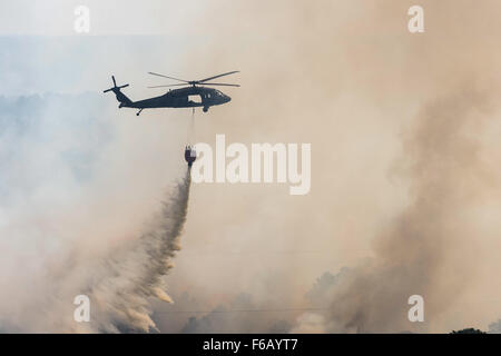 A Texas Army National Guard UH-60 Black Hawk out of the Austin Army Aviation Facility helps fight wildfires threatening homes and property near Bastrop, Texas, Oct. 14, 2015. (U.S. Army National Guard photo by Sgt. 1st Class Malcolm McClendon). Stock Photo