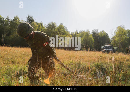 Canadian Army Master Cpl. Nicolas Pelletiec of the 3rd Battalion, Royal 22nd Regiment, 5th Canadian Mechanized Brigade Group drags a chain while conducting vehicle recovery operations during exercise Allied Spirit II at the U.S. Army’s Joint Multinational Readiness Center in Hohenfels, Germany, Aug. 9, 2015. Allied Spirit II is a multinational decisive action training environment exercise that involves over 3,500 Soldiers from both the U.S., allied, and partner nations focused on building partnerships and interoperability between all participating nations and emphasizing mission command, intel Stock Photo