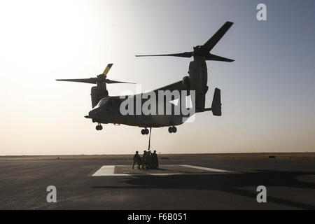 U.S. Marines and U.S. Army soldiers attach a cargo load to an MV-22 with a single point hook during External Cargo Lift Training conducted by Marine Medium Tiltrotor Squadron-165 (VMM-165), Special Purpose Marine Air-Ground Task Force—Crisis Response—Central Command, in an undisclosed location in Southwest Asia, June 5, 2015. The SPMAGTF’s organic MV-22 squadron, paired with its KC-130 refueling capabilities, allow it to respond to contingencies as a fully capable crisis response unit across the USCENTCOM Area of Operations. Stock Photo