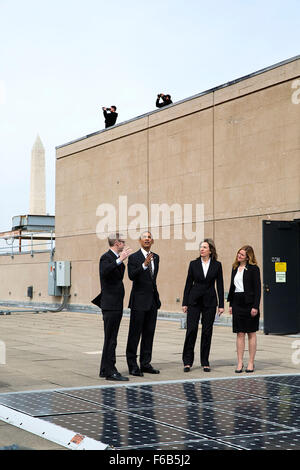 President Barack Obama looks at solar panels with Energy Department engineer Eric Haukdal on the roof of the Department of Energy in Washington, D.C., March 19, 2015. Liz Sherwood-Randall, Deputy Secretary of Energy and Kate Brandt, Federal Environmental Executive, Council of Environmental Quality, right, accompany them. Stock Photo