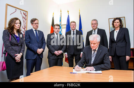 The Minister President of the German state of Bavaria Horst Seehofer (CSU) signs a condolence book at the French Consulate in Munich, Germany, 15 November 2015. The Consul General of France Jean-Claude Brunet (2nd l) and his wife Muriel (L), Bavarian Justice Minister Winfried Bausback (CSU, 3rd L-R), head of the Bavarian State Council, Marcel Huber (CSU), Bavarian Interior Minister Joachim Herrmann (CSU) and Bavarian Economics Minsiter   Ilse Aigner (CSU) look on from behind. At least 129 people were killed in a series of terrorist attacks in Paris, on 13 November 2015. Foto: MARC MUELLER/dpa Stock Photo