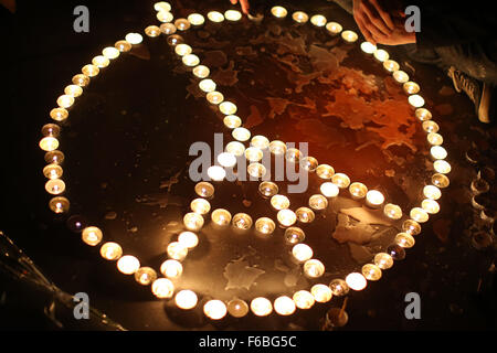 Paris, France. 15th Nov, 2015. People light candles and arrange then in the shape of a peace sign with the Eiffel Tower at the Place de la Republique in Paris, France, 15 November 2015. At least 129 people were killed during a series of overnight terror attacks in Paris from 13 to 14 November 2015. Photo: MALTE CHRISTIANS/dpa/Alamy Live News Stock Photo