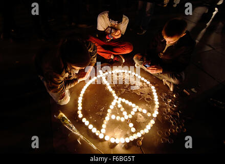 Paris, France. 15th Nov, 2015. People light candles and arrange then in the shape of a peace sign with the Eiffel Tower at the Place de la Republique in Paris, France, 15 November 2015. At least 129 people were killed during a series of overnight terror attacks in Paris from 13 to 14 November 2015. Photo: MALTE CHRISTIANS/dpa/Alamy Live News Stock Photo