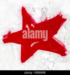 A red sad star painted on the wall with spray paint. Stock Photo