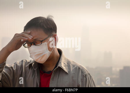 Asian man wearing mouth mask against air pollution Stock Photo