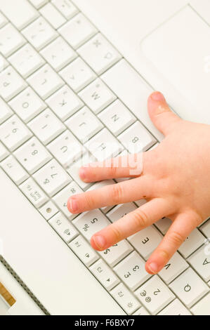Kid Computer Hand the child's hand on computer keyboard top view closeup Stock Photo - Alamy