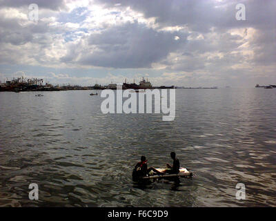 Filipino boys aboard an improvised raft paddle along the coast of Manila Bay in Navotas City, north of Manila, Philippines (Photo by Richard James Mendoza / Pacific Press) Stock Photo