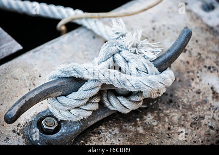 Nautical rope tied around horn cleat on dock, close up.  Key West harbor, Florida. Stock Photo