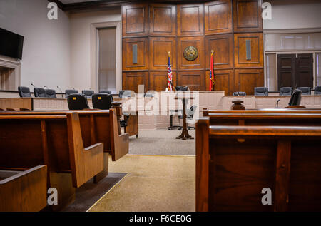 Empty Interior of small town TN court house with wooden benches, State Seal and flag, along with American flag near Judge's bench in Tennessee, USA Stock Photo