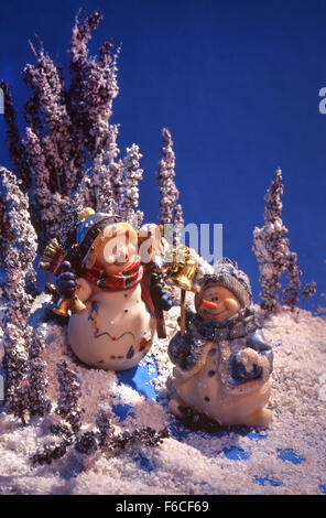 Festive New Year's, Christmas still life two fantastic toy snowmen at night in the wood with hand bells. sky blue, Stock Photo