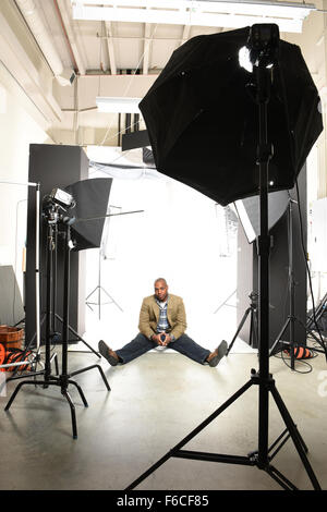 Young African American businessman sitting on floor of photo studio Stock Photo