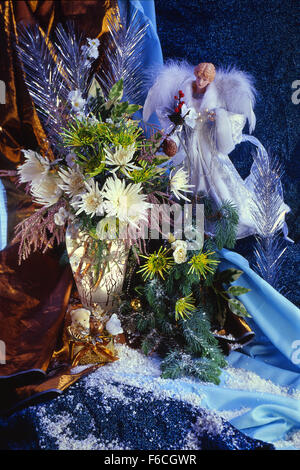 Festive New Year's, Christmas still life in blue tones a sbely angel and a bouquet of winter flowers of chrysanthemums. Stock Photo