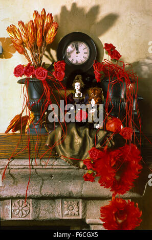 Festive New Year's, Christmas still life with two dolls and a bouquet of red roses, and also with an old watch. vertical format. Stock Photo