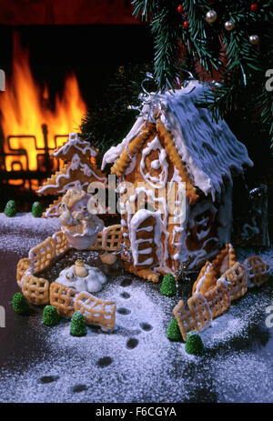Festive New Year's, Christmas still life with a gingerbread lodge and a bear cub toy against fire in a fireplace. Stock Photo