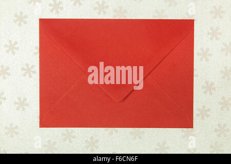 closed red envelope on snowflakes background, Christmastime Stock Photo
