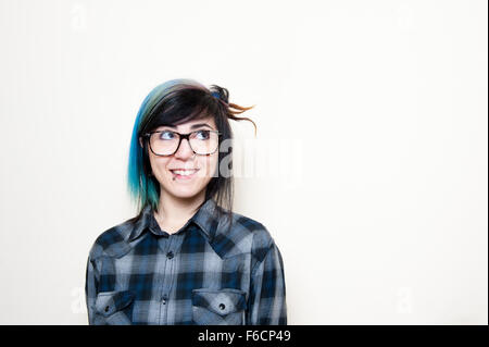 Young alternative girl with glasses in blue shirt portrait on white background Stock Photo