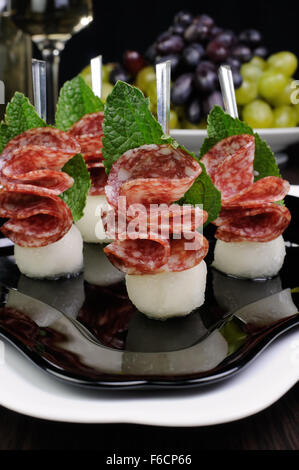 Canape of balls a melon and salami with mint Stock Photo