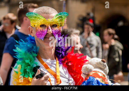 Flamboyant man with butterfly mask, garland and teddy bear. Stock Photo