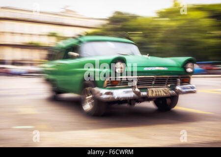 Speed, blurred, traveling old car, vintage green in the streets, old American road cruiser on the streets of Havana, Taxi, Stock Photo