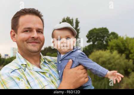 Portrait Of A Happy Father Clutching At His Chest His Eight Month Baby Boy Baby Stock Photo