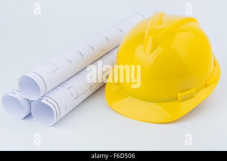Yellow safety helmet and Scrolls of engineering drawings. Stock Photo