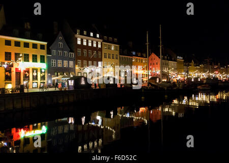 A Christmas decorated and illuminated Nyhavn reflected in the calm Nyhavn canal on a cool and dark November evening. Stock Photo