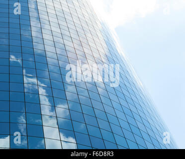 Modern glass skycrapers background with sky and clouds reflection. Stock Photo