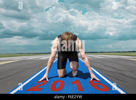 Male version of airport runway starter. Runner in start position kneels with lowered head on a blue tartan surface Stock Photo