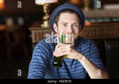 happy young man drinking beer at bar or pub Stock Photo