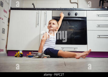 accident prevention. The child unattended playing in the kitchen with a gas stove. without retouch Stock Photo