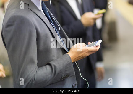 Businessmen using their cell phones on subway. Stock Photo
