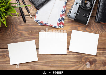 Blank photo frames, camera and supplies on wooden table. Top view. Stock Photo