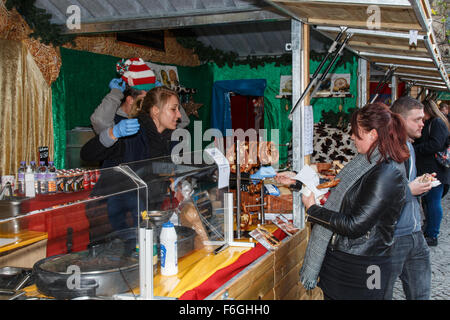Manchester Christmas market stall selling german food to a female visitor, Stock Photo
