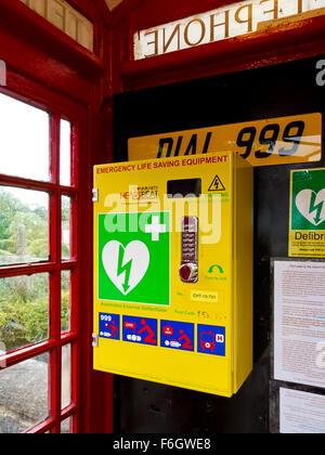 Defibrillator Emergency Life Saving Equipment installed in old red telephone box in Alport village Derbyshire Dales England UK Stock Photo