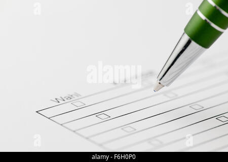 Close up of a green pen on a choice form with printed lines and boxes, and the word "Choice" in focus Stock Photo