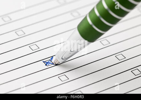 oblique close-up of einers green pen on a sheet of paper with lines crossing in a box Stock Photo