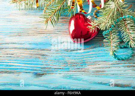 Red Christmas decorations and fir branch on a blue wooden background Stock Photo