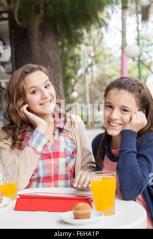 Two girls having fun at coffee store Stock Photo